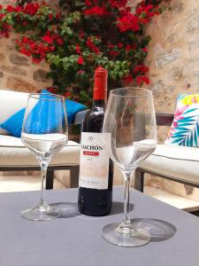 a bottle of wine and two wine glasses on a table at Casa Fénix in Altea