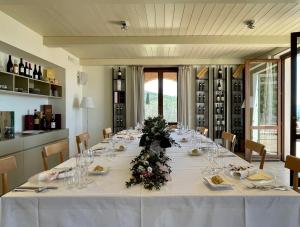 フォリーニョにあるLa Quercettaの白いテーブルクロスと花を飾った長テーブル