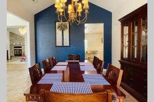 a dining room with a wooden table and a chandelier at Private mountain retreat with pool and mini-golf in Oakhurst