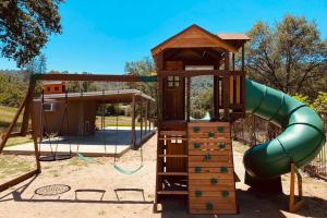 a playground with a slide and a play structure at Private mountain retreat with pool and mini-golf in Oakhurst