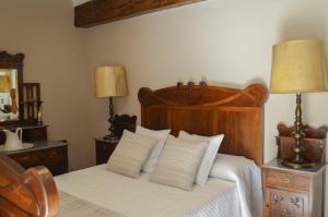 Un dormitorio con una gran cama de madera con almohadas blancas. en CAL MILIO, en Mayals 11 fotos más