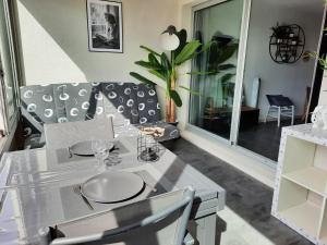 a dining room with a white table and chairs at CHARMANT T2 VUE MARINA PLAGES A PIED in Sète +13 photos