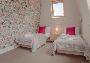 エディンバラにあるStockbridge Townhouse - The Edinburgh Addressのベッドルーム1室(ピンクの枕が付くベッド2台付)