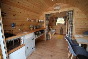 Cabaña de madera con cocina y sala de estar. en Glamping Huts in Heart of Snowdonia, en Dolgellau