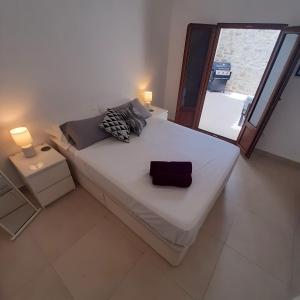 a bedroom with a large white bed with a window at Casa Fénix in Altea