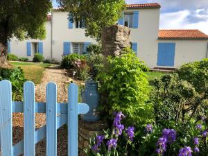 een blauw hek voor een huis met bloemen bij L'enclos bleu, vendée sud, marais poitevin in Chaillé-les-Marais