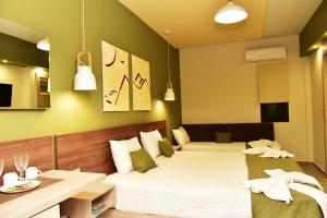 a hotel room with two beds and a table at Lafo Rooms in Elafonisi