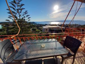 a table and chairs on the balcony of a house at Stefanos Studios in Lassi