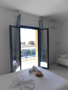 a room with a bed with a mirror and a hat at Mike's Beach Apartments & Studios in Hersonissos