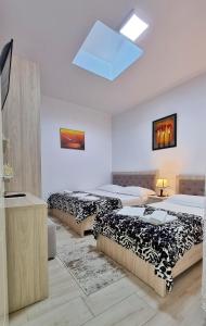 a room with three beds and a television in it at Downtown Apartment in Berat