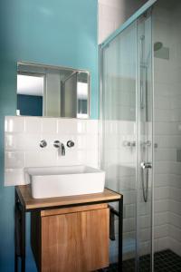 a bathroom with a sink and a shower at Un Hôtel En Ville in La Rochelle