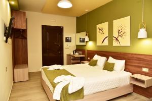 a bedroom with a large bed with green walls at Lafo Rooms in Elafonisi