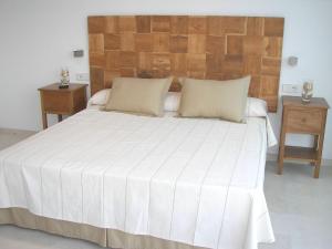 a bedroom with a large white bed with two night stands at Villa Mar in Cala en Blanes +17 photos