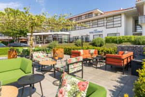 a patio with colorful chairs and tables in front of a building at Hotel Ameland in Nes