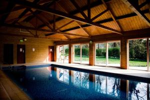 a swimming pool in a house with windows at The Grove Cromer in Cromer