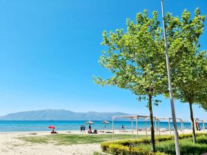 a beach with umbrellas and people on the beach at Sky - Apartment - Brown in Vlorë