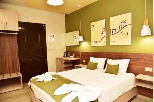 a hotel room with a bed with white sheets at Lafo Rooms in Elafonisi