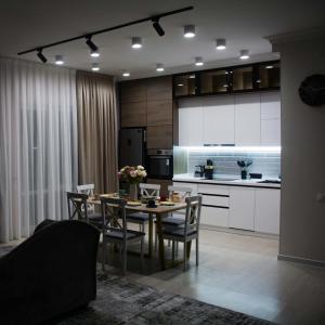 una cucina e una sala da pranzo con tavolo e sedie di Deluxe Apartment - Tamerlan Residence a Shymkent