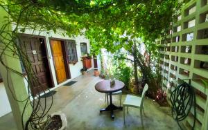 eine Terrasse mit einem Tisch und Stühlen sowie ein Gebäude in der Unterkunft Hechtech House in Accra