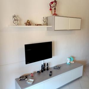 Appartamento Fonny Best Vacation Ever Villasimius في فيلاسيميوس: تلفزيون بشاشة مسطحة على جدار أبيض