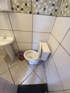 La salle de bains est pourvue de toilettes et d'un lavabo. dans l'établissement Pousada avenida 03, à São Thomé das Letras