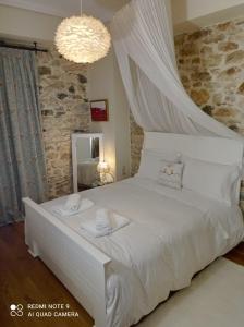 a bedroom with a white bed with a canopy at Νόνη in Mileai