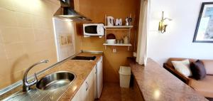 a small kitchen with a sink and a microwave at Granada Apartments Familiar Deluxe in Portinatx
