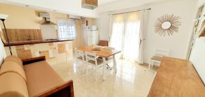 a kitchen and dining room with a table and a table and a couch at Granada Apartments Familiar Deluxe in Portinatx