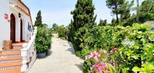 a garden with flowers and a white fence at Granada Apartments Familiar Deluxe in Portinatx