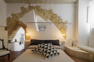 ein Wohnzimmer mit einem Bett und einer Steinmauer in der Unterkunft Castello House in Cagliari