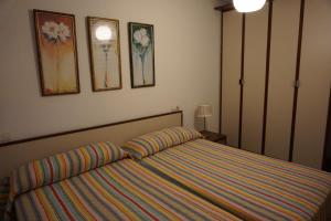 a bedroom with a bed and some pictures on the wall at Apartamento Faro de Tapia in Tapia de Casariego