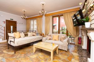 a living room with two couches and a fireplace at Medusa's Villas in Acharavi