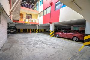 a parking garage with a red car parked in it at Hotel Cumbayá Sanvy in Quito