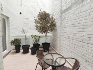 une terrasse avec une table, des chaises et des plantes en pot dans l'établissement GLOBAL Apartments & Rooms, à Barcelone
