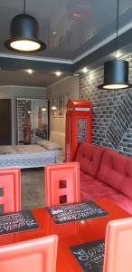 雅爾達的住宿－"Английский лофт"，一间设有红色电话亭和红色沙发的房间