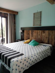 sypialnia z dużym łóżkiem z drewnianym zagłówkiem w obiekcie L'atelier w mieście Saint-Maximin