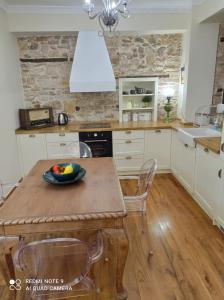 a kitchen with a wooden table with a bowl of fruit on it at Νόνη in Mileai