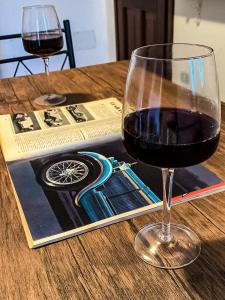 una copa de vino tinto en una mesa en La dimora del Murales - Holiday home, en Badesi