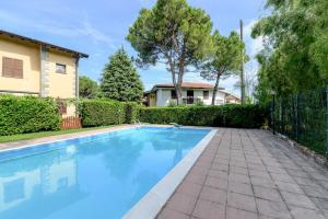 ein Schwimmbad in einem Hof neben einem Haus in der Unterkunft Bell'Italia Holiday Apartment Peschiera in Peschiera del Garda