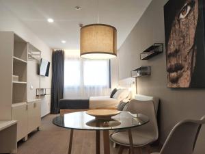 una pequeña sala de estar con una mesa y una cama en GLOBAL Apartments & Rooms en Barcelona