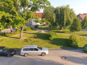 two cars parked in a parking lot in a park at Modernes Appartement nur 5 km von Erfurt, stilvoll komfortabel und perfekt angebunden, Kaffeevollautomat, TV, WLAN, Schlafsofa und Einkaufsmöglichkeiten in der Nähe, hervorragende Anbindung zur A4 und A71, kostenlose öff Parkplätze für PKW und Transporter in Elxleben