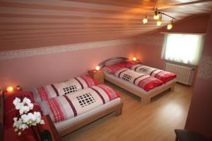 two beds in a room with red and white pillows at Hotel Klein Matterhorn in Randa