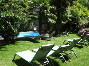 a group of lawn chairs and a swimming pool at Hotel Laperouse in Albi