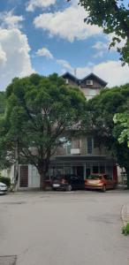 a large building with cars parked in front of it at Apartman Vid in Soko Banja