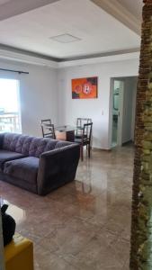 a living room with a couch and a table at Apartamento De Alto Padrão - Ocian in Praia Grande