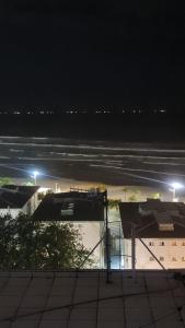 a view of the ocean at night from a building at Apartamento De Alto Padrão - Ocian in Praia Grande