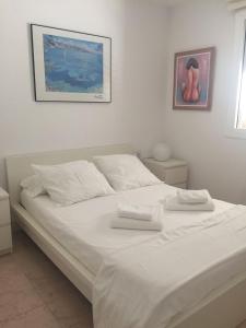 ein Schlafzimmer mit einem weißen Bett mit zwei Handtüchern darauf in der Unterkunft Sitges Aiguadolç playa in Sitges