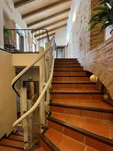 un escalier dans un bâtiment avec des carreaux bruns dans l'établissement APARTAMENTOS RURALES POSADA DE LLERENA, à Llerena