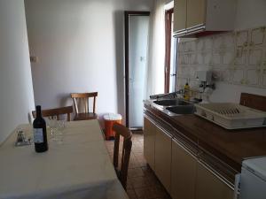 una cucina con un tavolo con una bottiglia di vino sopra di Assato Retro Apartment a Vodice