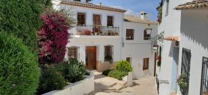 a white house with a balcony with flowers at Casa Fénix in Altea